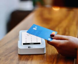 a person holding a credit card in front of a machine