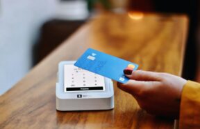 a person holding a credit card in front of a machine