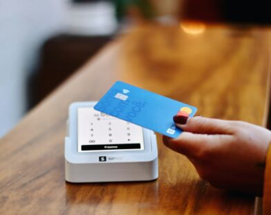 a person holding a credit card in front of a machine