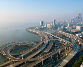 an aerial view of a highway with a city in the background