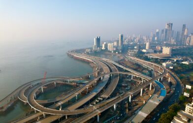 an aerial view of a highway with a city in the background