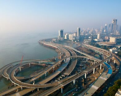 an aerial view of a highway with a city in the background