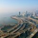 an aerial view of a highway with a city in the background
