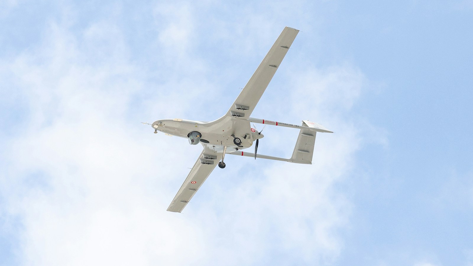 A small airplane flying through a blue sky