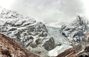 A mountain range covered in snow and clouds