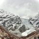 A mountain range covered in snow and clouds
