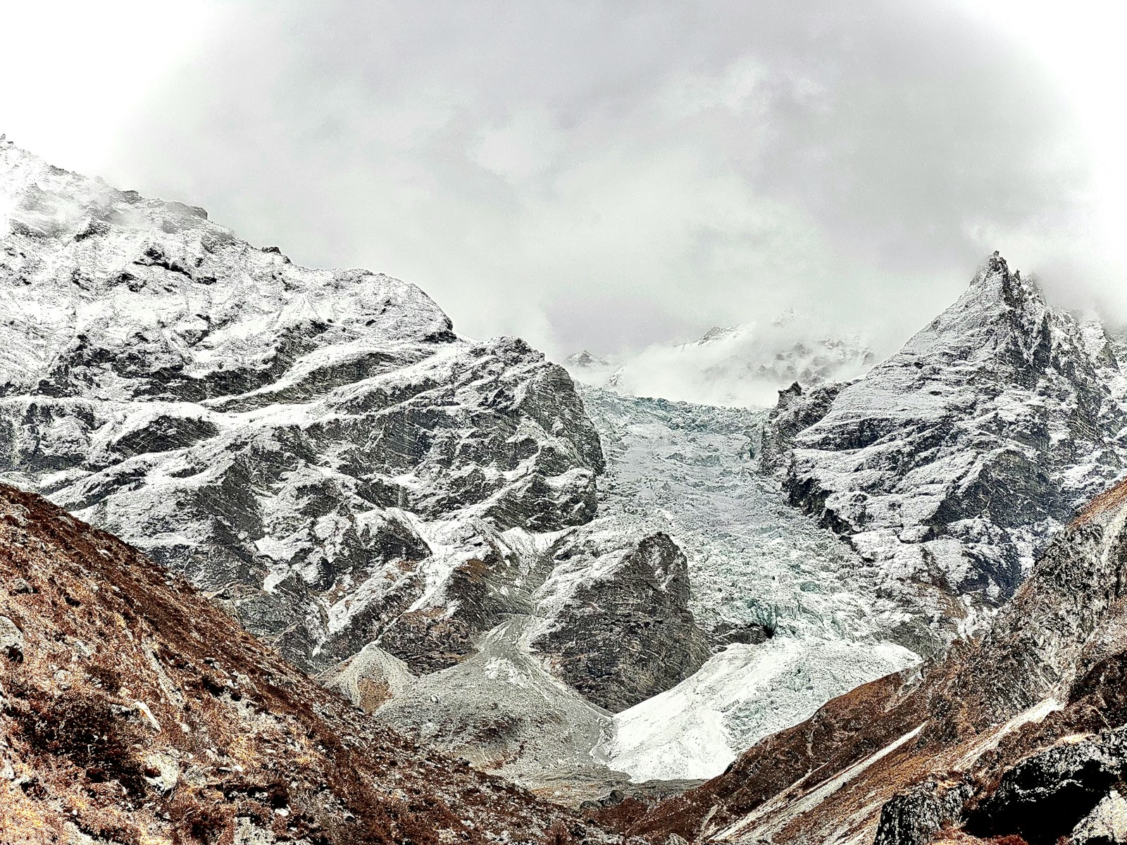 A mountain range covered in snow and clouds