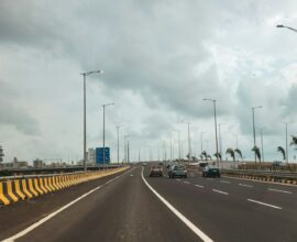 Cars are driving on a long, empty highway