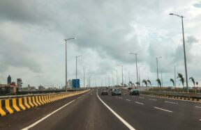 Cars are driving on a long, empty highway