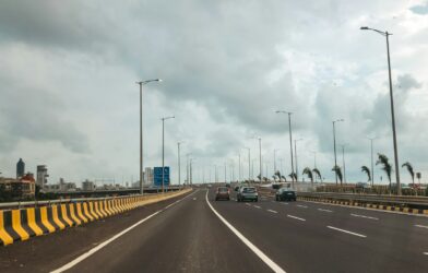 Cars are driving on a long, empty highway