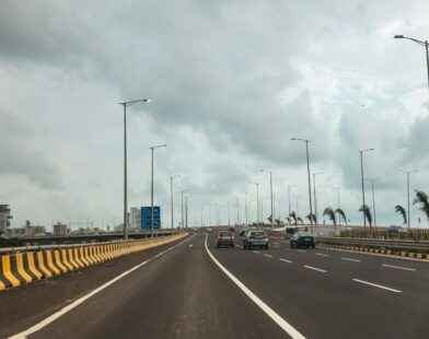 Cars are driving on a long, empty highway