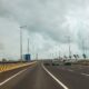 Cars are driving on a long, empty highway