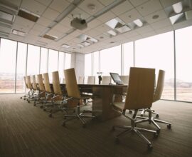 oval brown wooden conference table and chairs inside conference room