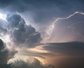A dramatic lightning strike illuminates stormy clouds