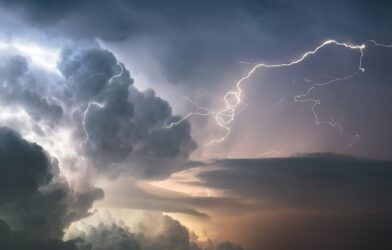 A dramatic lightning strike illuminates stormy clouds