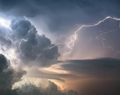 A dramatic lightning strike illuminates stormy clouds