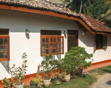 A white house has wooden windows and a red roof