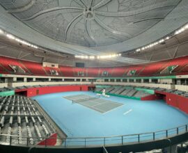 a tennis court with a blue floor and red seats