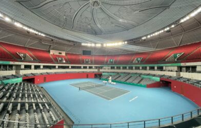 a tennis court with a blue floor and red seats