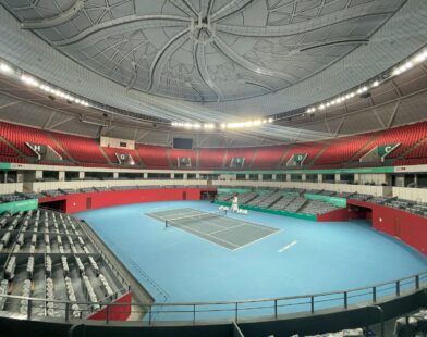a tennis court with a blue floor and red seats