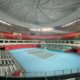 a tennis court with a blue floor and red seats