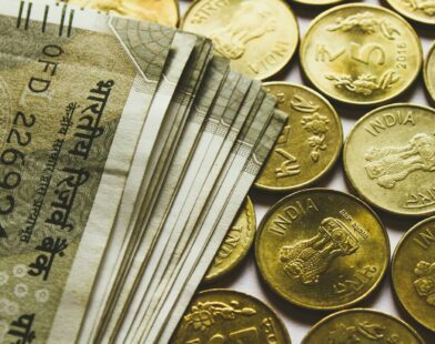 round gold-colored rupee coins and banknotes