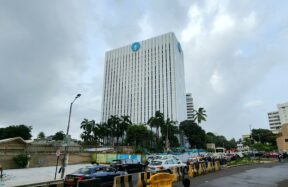 A tall bank building stands under a cloudy sky