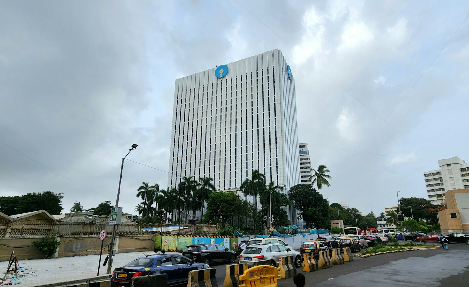 A tall bank building stands under a cloudy sky