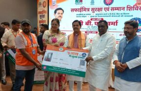 कार्यक्रम में सुरक्षा उपकरण और किट वितरित करते हुए लोग