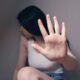 woman in white tank top covering face with her hands