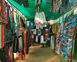 Colorful clothing and flip-flops displayed at a market stall