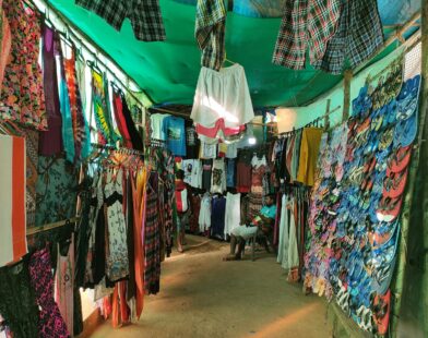 Colorful clothing and flip-flops displayed at a market stall