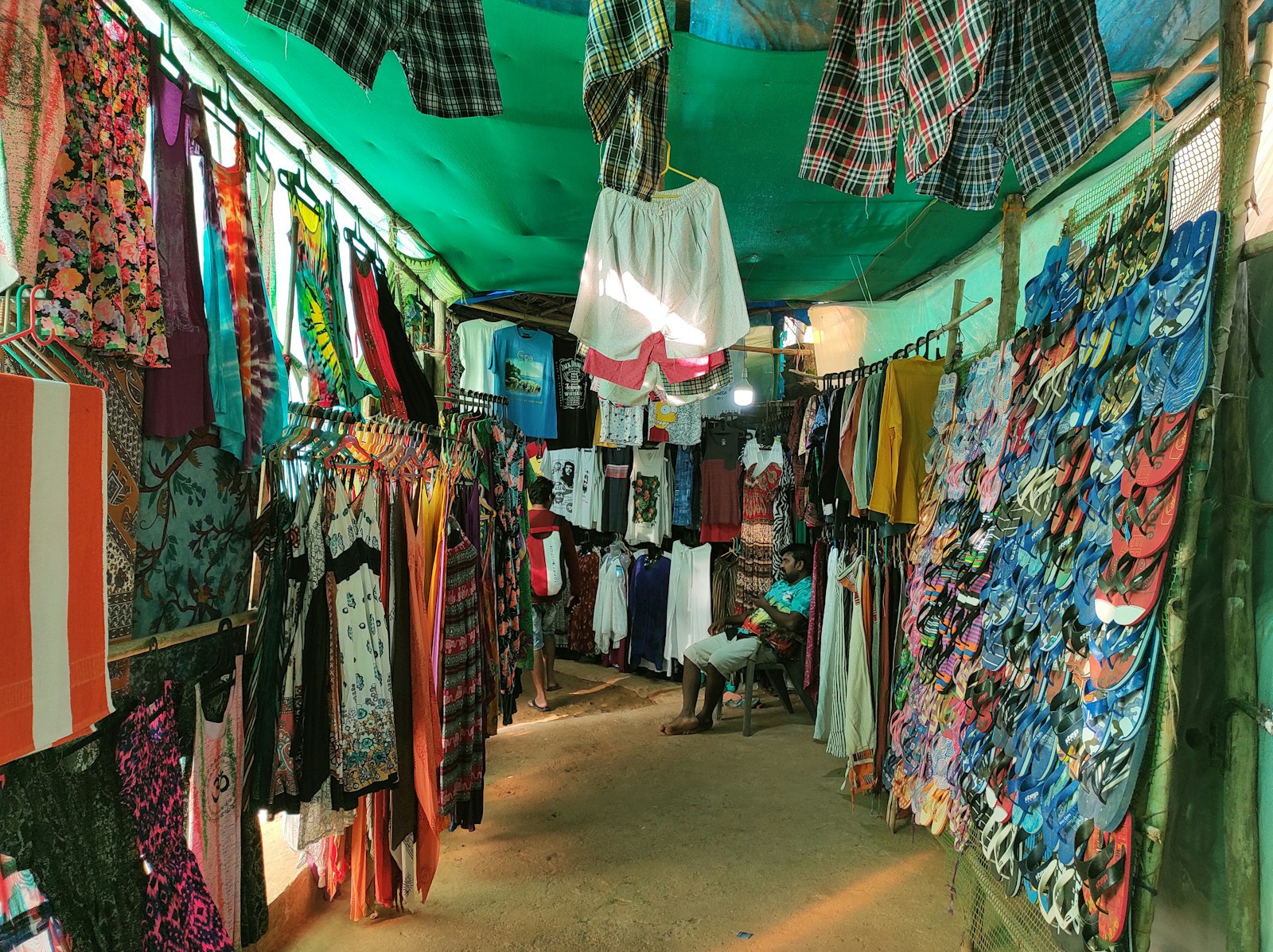 Colorful clothing and flip-flops displayed at a market stall