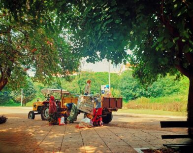 a man standing next to a truck under a tree