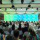 Audience watches a presentation on a large screen