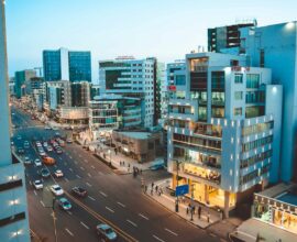 Busy city street with cars and tall buildings at dusk