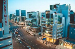 Busy city street with cars and tall buildings at dusk