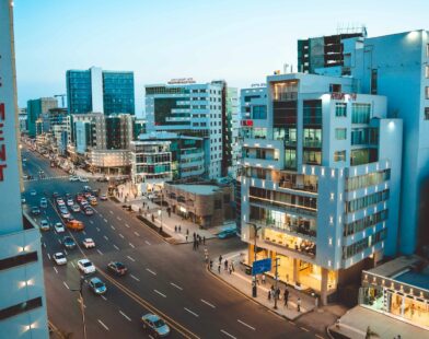 Busy city street with cars and tall buildings at dusk