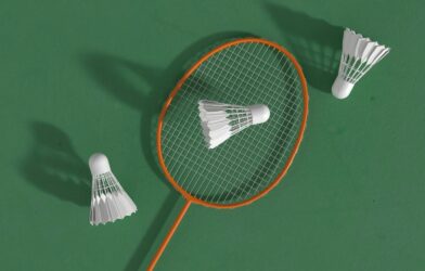 a badminton racket and two shuttles on a green surface