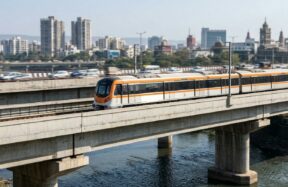 A modern train travels on an elevated track over water
