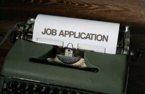 a typewriter with a job application printed on it