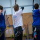 Three archers aiming at targets in an indoor range