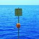 a sign on a pole in the middle of a body of water